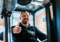 Mann in Gabelstapler gibt den Daumen hoch