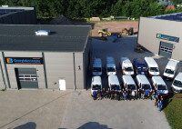 Das Team von EB vor dem Firmengebäude und den Unternehmensfahrzeugen